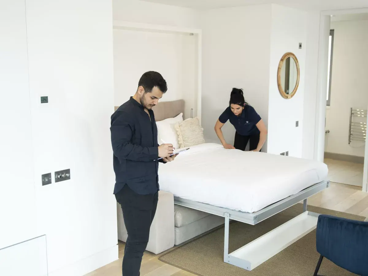 UF Cleaning hospitality team inspecting a prepared hotel bedroom